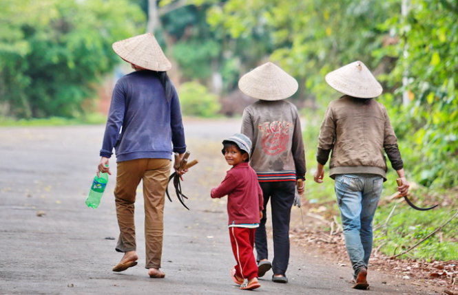 Những công nhân môi trường cùng con nhỏ đi trên đường từ khu công viên hồ Ea Kao về nhà - Ảnh: Tiến Thành